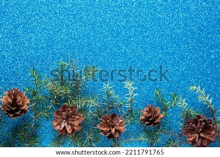 Christmas blue background with fir branches. Frame made of fir tree branches and cones with copy space. Christmas wallpaper concept. Top view