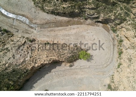 aerial photo of a river in the south of Spain, there is a water source, there is a tree and bushes