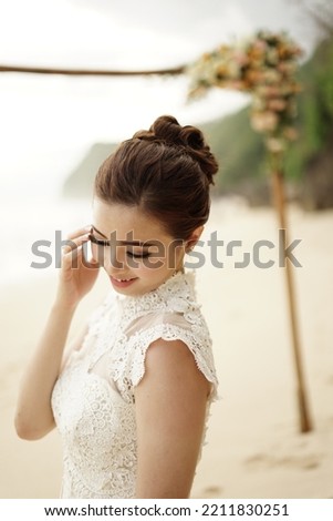 a chinese woman is wearing wedding dress having photo session in the beach