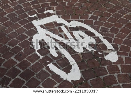 White bicycle symbol was painted on the bicycle lane made of cobblestone somewhere in Bruges
