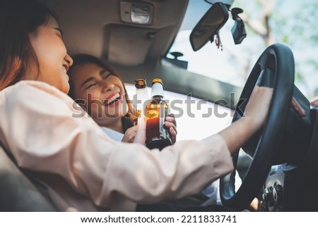 Blurred soft images, 2 Asian woman driving in a drunken state as a result of drinking alcohol, concept to drinking alcohol while driving it is the cause of accidents on the road. Royalty-Free Stock Photo #2211833741