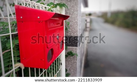 post box on fence with road blur background