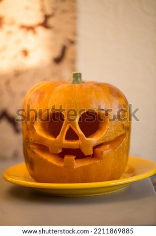 Halloween curved pumpkin in the yellow plate.