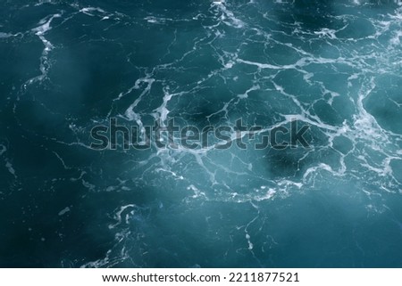 The wave foam pattern on the surface of the blue sea.