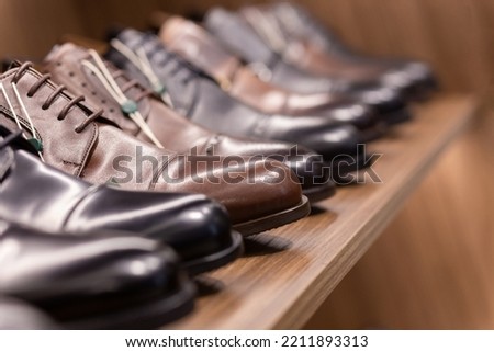 Leather shoes were lined up on the store shelves. Men elegant shoes in a man clothing boutique. Some models are sold at a discount. Royalty-Free Stock Photo #2211893313