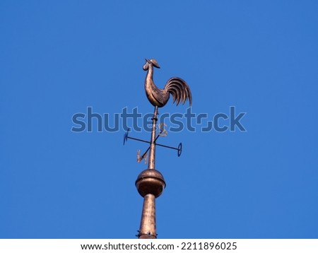 A weather vane on a church tower, here a catholic church.