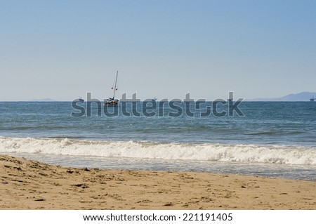 Sailboat off the coast of California with oil rigs in background