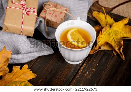 Autumn still life. Hot tea with lemon, yellow maple leaves and cozy sweater on wooden background. fall mood, Autumn decor, Fall season concept. thanksgiving and halloween holiday. flat lay, 