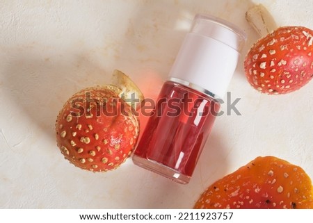 transparent bottle with red fly agaric tincture, medicinal properties of fly agaric for cosmetics and medicines, fly agaric extract, narcotic properties of fly agaric extract Royalty-Free Stock Photo #2211923757