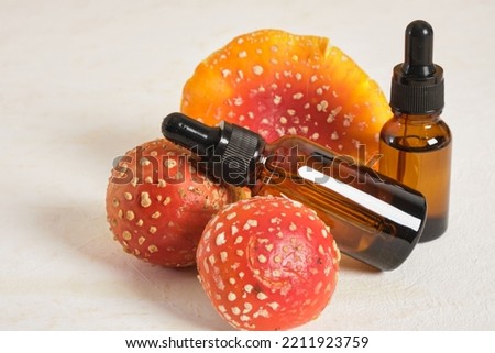 fly agaric red and amber glass dropper bottles, fly agaric extract for skin and joints treatment, fly agaric microdosing, biohacking to improve the state of the body and mind Royalty-Free Stock Photo #2211923759