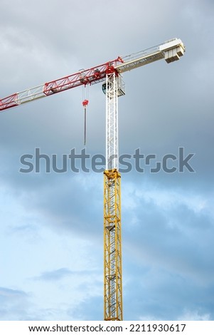Tower crane against moody sky. Construction site. 