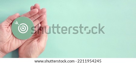 Hand holding target paper cut, achieve on point, sustianable challenge goal, business objective plan concept Royalty-Free Stock Photo #2211954245