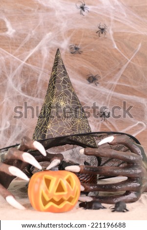 Halloween witch hands, hat and Jack O' Lantern pumpkin ornament close up