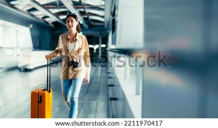 International airport terminal. Asian beautiful woman with luggage and walking in airport Royalty-Free Stock Photo #2211970417
