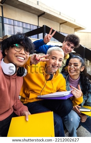 Multiracial gen z friends taking selfie with phone outside university building. College students having fun. Vertical.