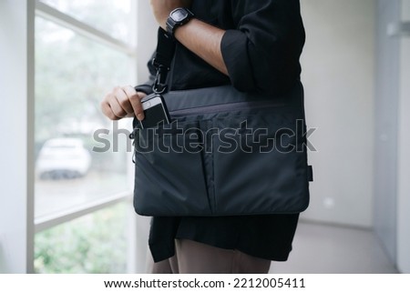 close up man hand put his hand phone in his bag pocket Royalty-Free Stock Photo #2212005411