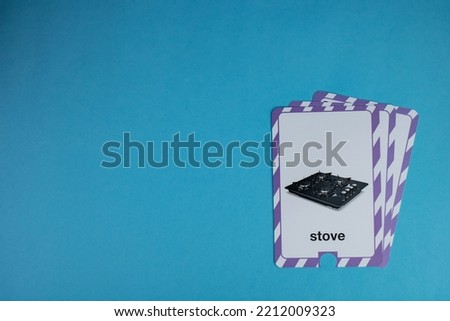 Flashcard with photo of the stove in black, placed on the right of a blue background.