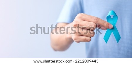 Blue November Prostate Cancer Awareness month, Man in blue shirt with hand holding Blue Ribbon for support people life and illness. Healthcare, International men, Father, Diabetes and World cancer day Royalty-Free Stock Photo #2212009443