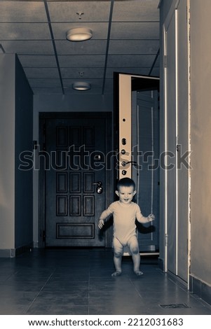 Toddler baby leaves the open door of the apartment. Child boy runs away from home. Kid age one year