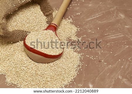 quinoa groats with a wooden spoon in a canvas bag on the table. High quality photo