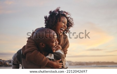 Black couple, travel and beach fun while laughing on sunset nature adventure and summer vacation or honeymoon with a piggy back ride. Comic, energy and black man and woman love on ocean holiday Royalty-Free Stock Photo #2212042697
