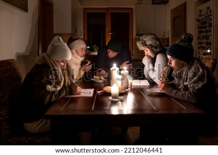Family of five suffers in no heating and no electricity during an energy crisis in Europe causing blackouts. Royalty-Free Stock Photo #2212046441