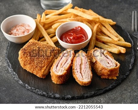 Fried chicken Cordon bleu with cheese and ham in breadcrumbs with french fries Royalty-Free Stock Photo #2212055543