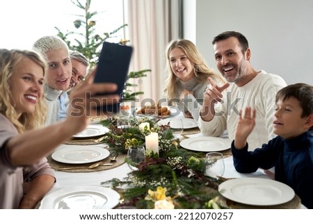 Caucasian family of different generation taking selfie over Christmas table 