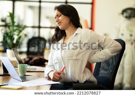 Portrait of tired businesswoman. Young woman having back pain. Royalty-Free Stock Photo #2212078827