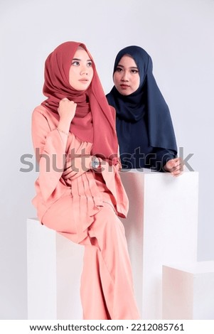 Muslim woman wearing traditional wear and hijab isolated on grey background. Idul Fitri and hijab fashion concept