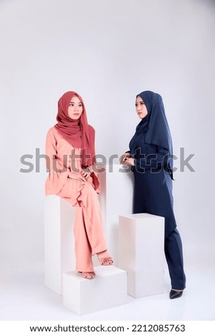 Muslim woman wearing traditional wear and hijab isolated on grey background. Idul Fitri and hijab fashion concept