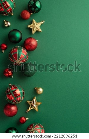 Christmas tree decorations concept. Top view vertical photo of star ornaments gold green and red baubles on isolated green background
