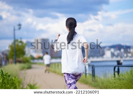 Young Japanese woman exercising outdoors Royalty-Free Stock Photo #2212106091