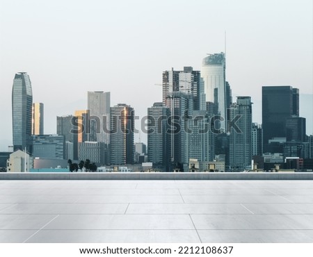 Empty concrete rooftop on the background of a beautiful Los Angeles city skyline at sunset, mockup