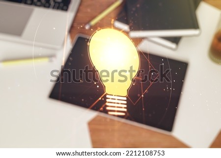 Creative light bulb illustration and modern digital tablet on desktop on background, top view, future technology concept. Multiexposure