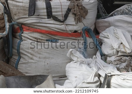 Close up on a large sandbag on a construction site in Paris. The bags are white, the focus is on the center bag. Vignetting