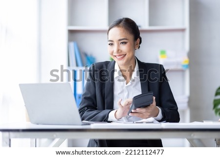 Asian female accountant or banker making calculations. Young business asian woman in workplace, Documents, tax, report for analysis Savings, finances and economy concept.
