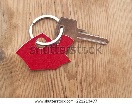Symbol of the house with silver key on vintage wooden background 