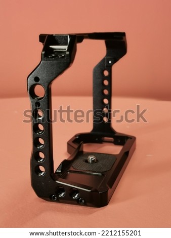 A black metal camera cage for a DSLR.