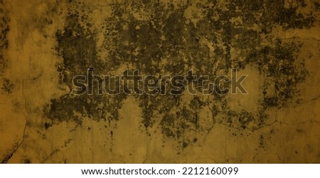 a unique old wall with a yellow combination of cracked textures, an old wall background with a mixture of moss, peeling yellow paint on an old abandoned house.