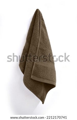 Brown Towel On A Towel Hook Against A White Wall Royalty-Free Stock Photo #2212170741