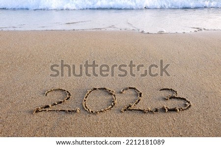 New year 2023 handwritten in the sand surface