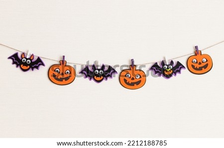 Halloween decoration on wall, pumpkins and bats garland with scary faces. Halloween celebration. copy space Royalty-Free Stock Photo #2212188785