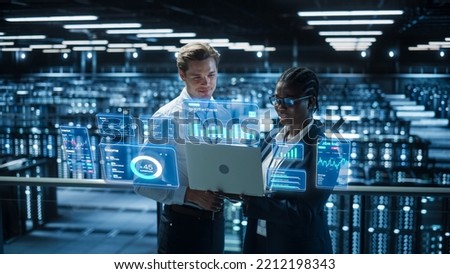 Technical Engineer and Project Administrator Using Computer in Modern Data Center Server Room Facility. Augmented Reality Productivity and Corporate Business Data Icons Appear From Worker's Laptop.
