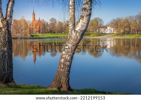 Peaceful city park and the church from the lake Druskonis at sunrise, lithuania
