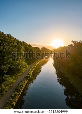 Beautiful sunset over a river with green bushes and color rich sky. High quality photo