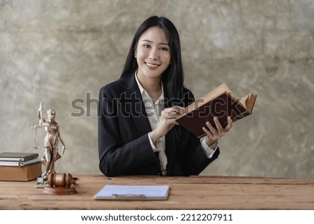 Young Asian lawyer working in office with laptop concept of justice and law. lawyer work
About the contract documents of brass scales on a wooden table Legal services, advice, justice