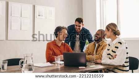 Cheerful designers smiling happily while having a meeting in an office. Group of successful businesspeople working on a new interior design project in a creative workplace. Royalty-Free Stock Photo #2212210559