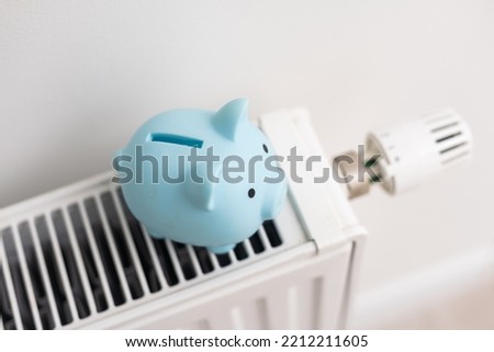 Piggy bank on central heating radiator. Concept image for saving money on heating