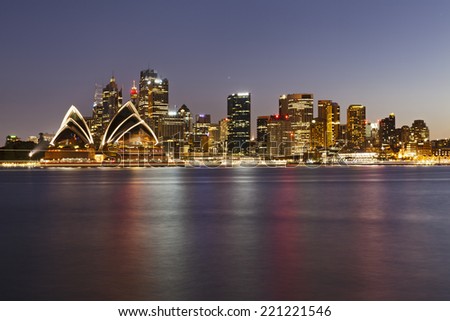 Australia Sydney city CBD landmarks view over harbour at sunset with illumination and blurred lights reflecting in still water
